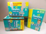 three boxes of pampers baby dry diapers sitting on a table