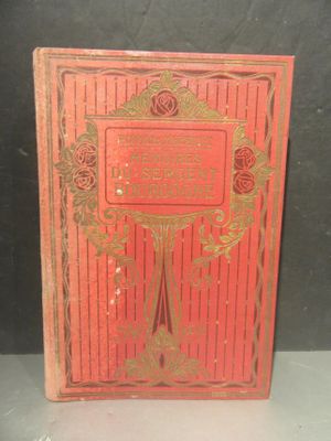 un livre rouge orné de lettres dorées, posé sur une table