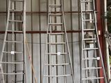 plusieurs échelles appuyées contre un mur dans un garage