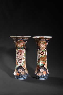 pair of vases with floral designs on them against a black background