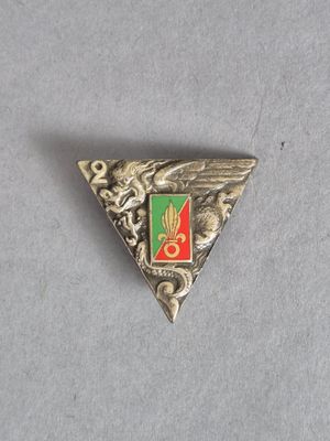 une image représentant un triangle argenté orné d'un emblème vert et rouge