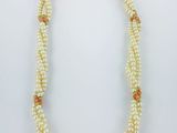un collier de perles blanches orné de perles roses et dorées