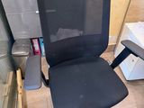 a black office chair sitting in front of a computer desk