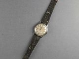 an image of a watch on a gray surface with a black strap