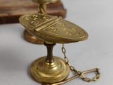several antique brass objects are displayed on a white surface