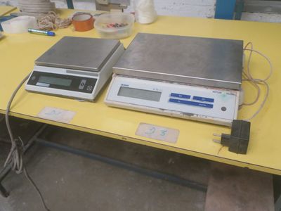 two electronic scales sitting on a yellow table