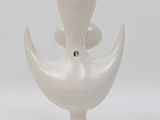 a white vase that is sitting on a stand
