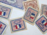 several french bank notes with french flags on them on a table