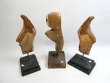 trois sculptures en bois représentant un visage de femme et une tête d'homme