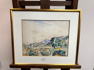 aquarelle encadrée représentant un paysage, posée sur un chevalet en bois