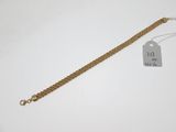 une photo d'un bracelet en or auquel est attachée une étiquette