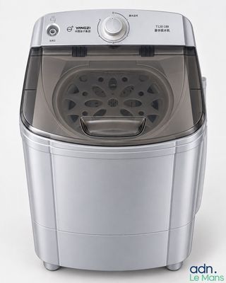 une image représentant une petite machine à laver posée sur une surface blanche