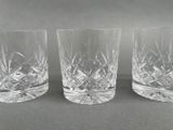 three crystal tumblers sitting on top of a table next to each other