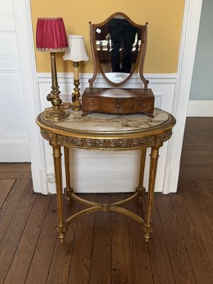 une petite table sur laquelle se trouvent un miroir et une lampe