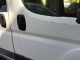 a white van with black trims parked on the side of the road