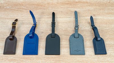 quatre étiquettes à bagages sont alignées sur une surface en bois