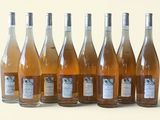 six bouteilles de vin sont alignées sur une surface blanche