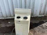 an old white stove sitting in front of a metal building