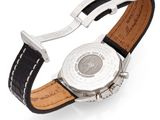 a close up of a watch on a white surface with a black strap