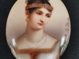 un gros plan sur un bouton représentant une femme portant des perles