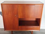 a wooden cabinet with two doors and a shelf on top of it