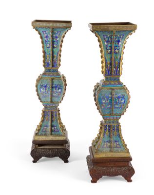 une paire de vases bleus et dorés posés sur un socle en bois