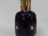 a black vase with gold decorations on it on a white surface
