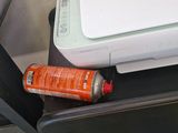 a printer sitting on top of a desk next to a bottle of water