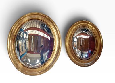 two mirrors that are on the wall next to each other
