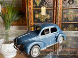 a toy car sitting on a glass table next to a potted plant