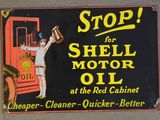 un panneau indiquant « Arrêtez-vous pour acheter de l'huile moteur Shell près de l'armoire rouge »