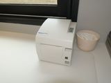 a white printer sitting on a counter next to a window