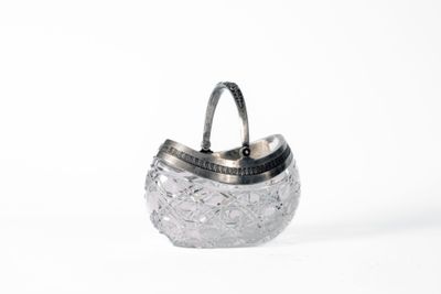 a silver purse with a handle on a white surface