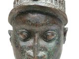 a close up of a bronze head with a hat on it