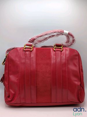 a red leather handbag with a rope on the handle