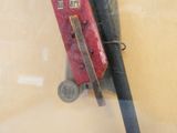 a red pocket knife hanging on a wall next to a baseball bat