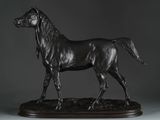 statue of a black horse on a wooden base on a gray background