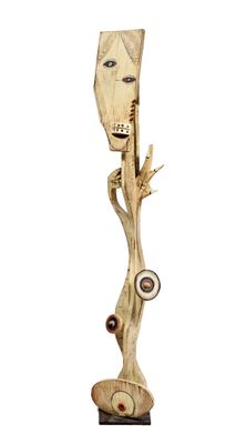 sculpture en bois représentant un homme dont le visage est sculpté sur une branche d'arbre