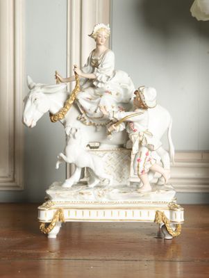 a figurine of a woman riding a horse with a man on it
