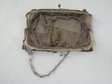 an old silver purse with a chain hanging from it ' s side