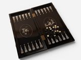 a black backgam board with silver and gold pieces