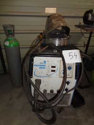 une machine qui se trouve dans un garage, à côté d'un bidon d'essence