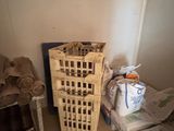 a small room with a bed and a basket on the floor