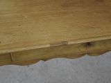 a close up of a wooden table with a drawer on it