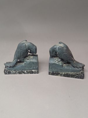 deux statues représentant un chien et un chat, posées sur un socle en pierre