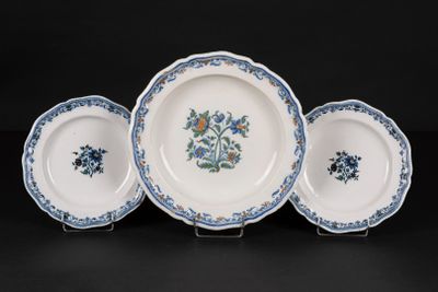 three blue and white plates with flowers on them on a black surface