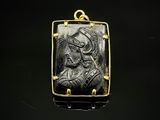 un pendentif noir et doré représentant une femme de profil