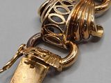 a gold bracelet that has a lock on it