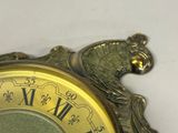 a close up of a clock on a white surface