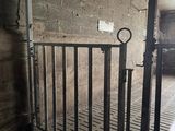 a metal gate in a building with a truck in the background